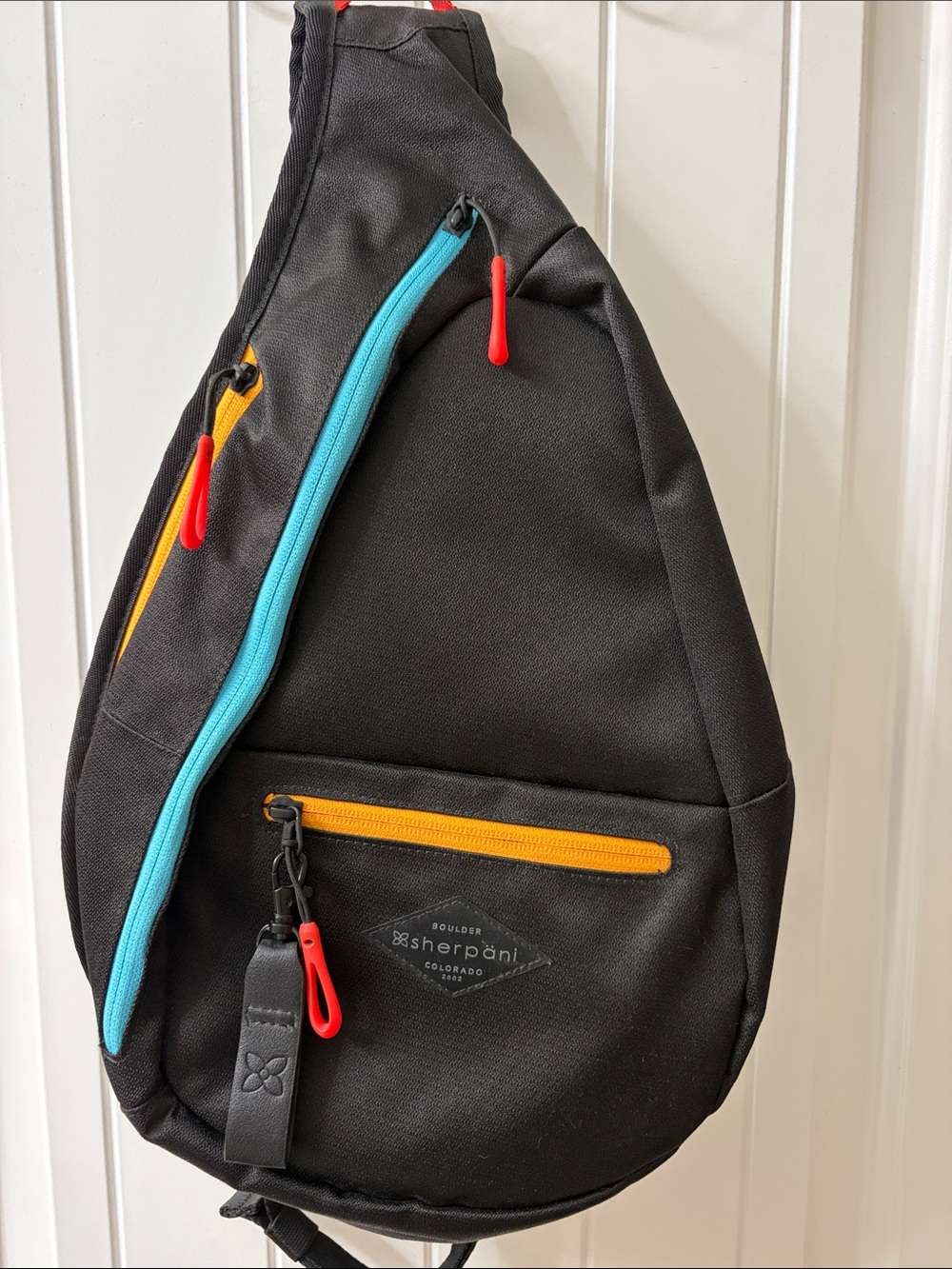 Sherpani Esprit Black Sling Bag with Turquoise, Yellow and Red Accents